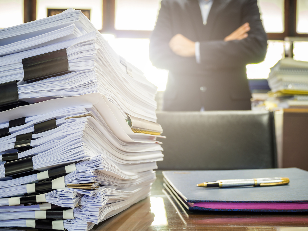 Close up of business documents stack on businessman background. Spring Clean Your Finances concept