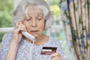 Senior Woman Giving Credit Card Details On The Phone Tax Scam