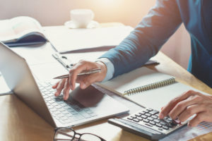 businessman working in office with using calculator and laptop. tax extension