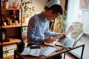 Man calculating his financial bills on a balance sheet for his business