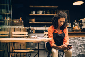 small business owner looking over finances on phone