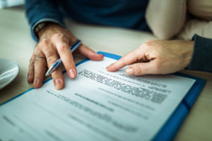 Close up of signing a SBA loan contract in the office.